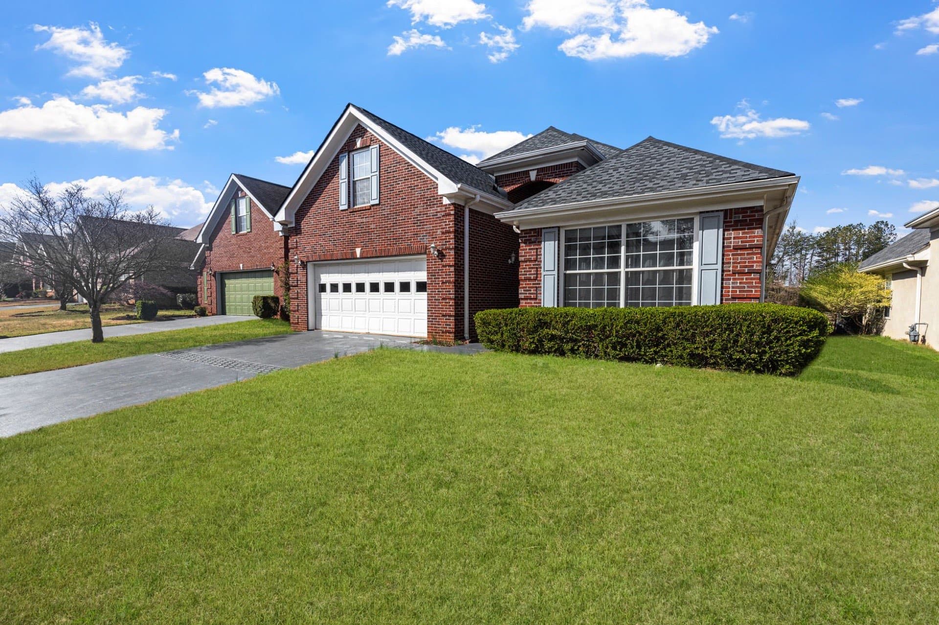 Freshly washed red brick home with a clean driveway and green lawn in the Dallas-Fort Worth suburbs